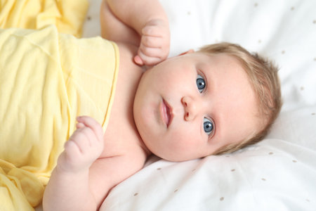 Cute newborn baby in bed at home