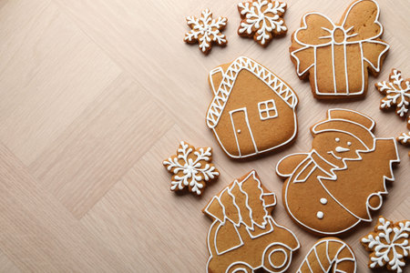 Tasty gingerbread cookies on light wooden table, flat lay. Space for textの写真素材