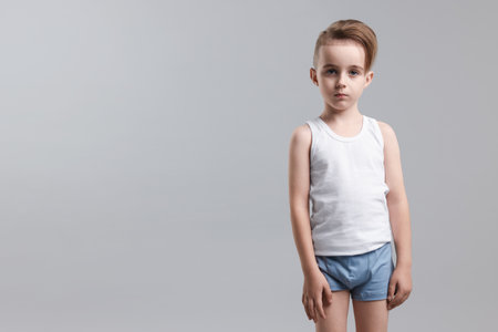 Little boy in underwear on light gray background. Space for textの写真素材