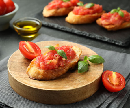 Tasty bruschettas with tomatoes and basil served on black table, closeupの写真素材