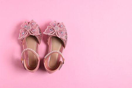 Pair of stylish kid's shoes on pink background, flat lay. Space for textの写真素材