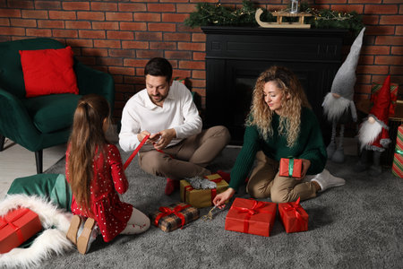 Happy family decorating Christmas gifts at homeの写真素材