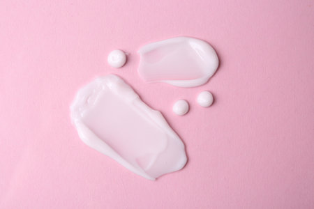 Samples of moisturizing creams on pink background, flat layの写真素材