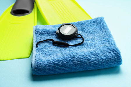 Flippers, digital stopwatch and towel on light blue background, closeupの写真素材
