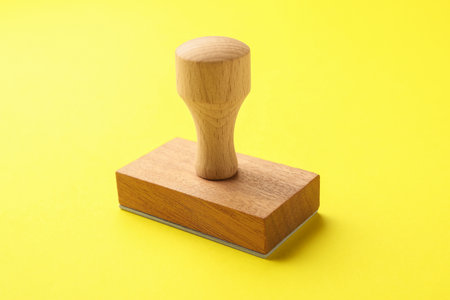 One wooden stamp on yellow background, closeup