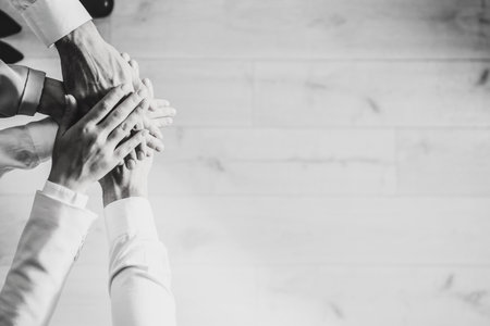 People holding hands together, top view with space for text. Black and white toning. Unity conceptの写真素材