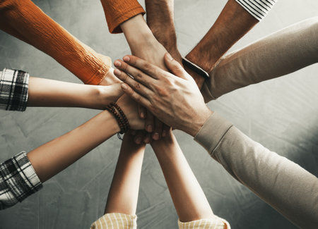 People holding hands together indoors, top view. Unity concept