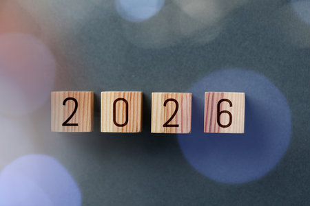 New 2026 year. Cubes with numbers on gray background, top view. Bokeh effectの写真素材