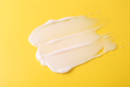 Sample of moisturizing cream on yellow background, closeupの写真素材