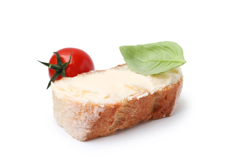 Slice of baguette with butter, basil and tomato isolated on whiteの写真素材