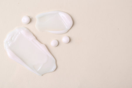 Samples of moisturizing creams on beige background, flat lay. Space for textの写真素材
