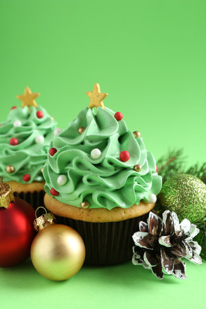 Christmas tree shaped cupcakes and festive decor on green background, closeupの写真素材