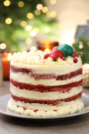 Delicious sponge cake with Christmas decor and red currants on gray textured table against blurred...