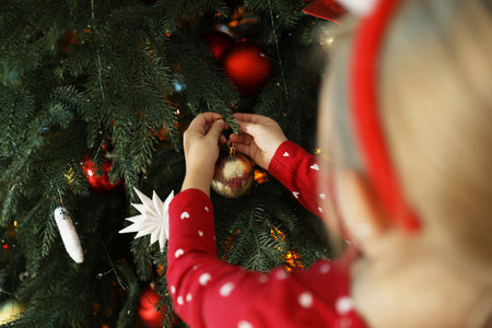 Little girl decorating Christmas tree at home, closeupの写真素材
