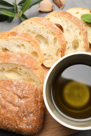 Slices of ciabatta, oil and other spices on table, top view