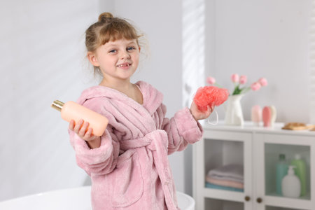 Happy girl in bathrobe with bathroom necessities indoorsの写真素材