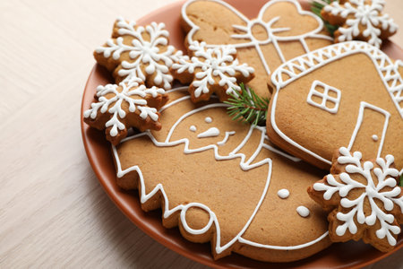 Tasty gingerbread cookies and fir tree branches on light wooden table, closeupの写真素材