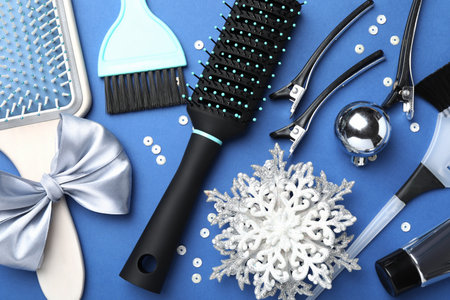 Different hairdresser's tools and Christmas decor on blue background, flat layの写真素材