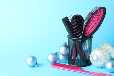 Different hairdresser's tools and Christmas decor on light blue background, closeup. Space for textの写真素材