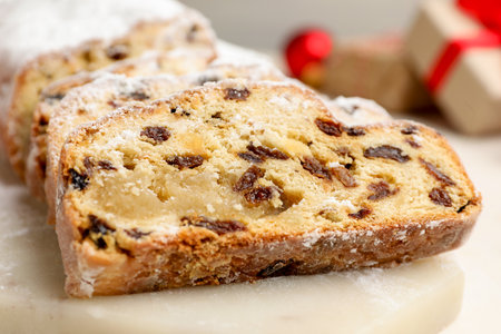 Slices of Stollen (traditional Christmas cake) on white table, closeup