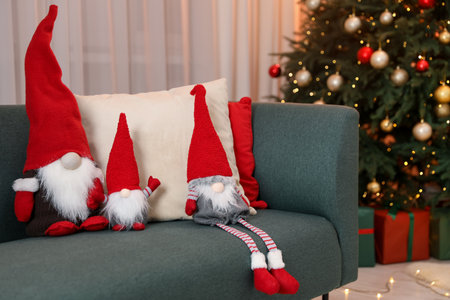 Funny Christmas gnomes on sofa in decorated roomの写真素材