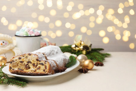 Cut traditional Stollen cake, drink and Christmas decor on white table. Space for textの写真素材