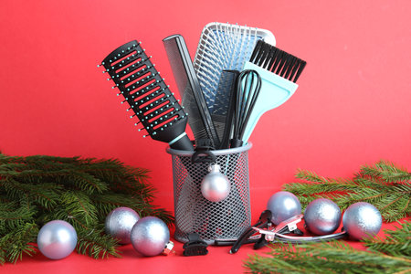 Different hairdresser's tools and Christmas decor on red background, closeupの写真素材
