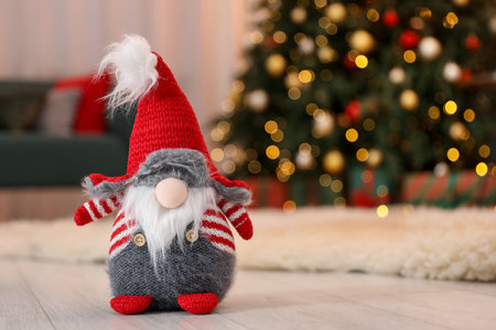 Funny Christmas gnome on floor in decorated room, closeup. Space for textの写真素材