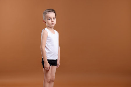 Little boy in underwear on brown background. Space for textの写真素材