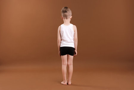 Little boy in underwear on brown background, back viewの写真素材