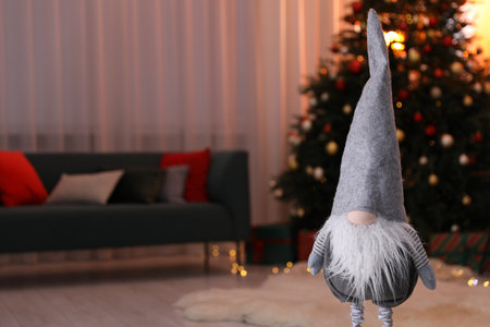 Funny Christmas gnome in decorated room, closeup. Space for textの写真素材