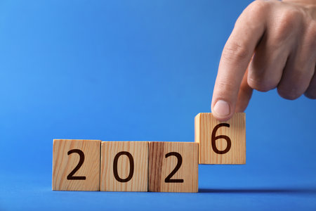 Man putting cube with number 6 on blue background, closeup