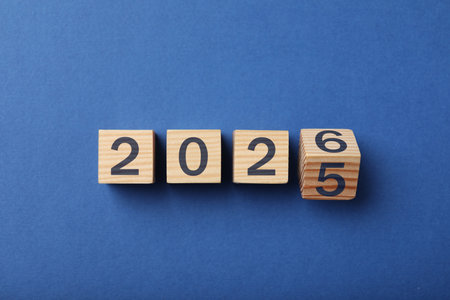 Flipping cube with number 5 and 6 to make 2026 on blue background, top viewの写真素材
