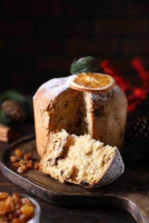 Christmas food. Delicious Panettone cake and festive decor on wooden table, closeupの写真素材