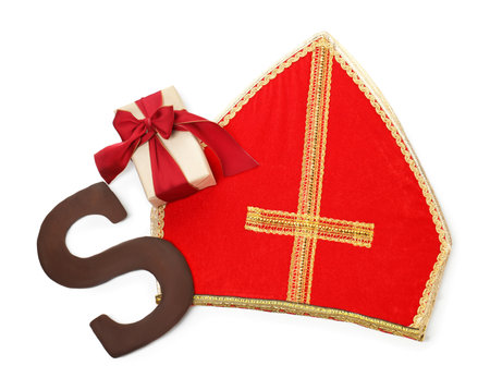 Saint Nicholas (Sinterklaas) day. Red mitre, chocolate letter S and gift box isolated on white, top viewの写真素材