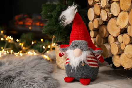 Funny Christmas gnome on floor in decorated room, closeup. Space for textの写真素材