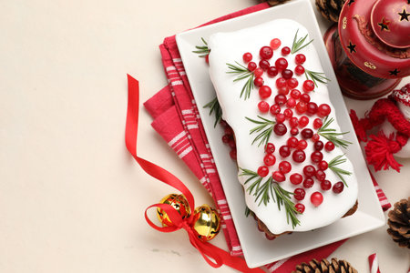 Tasty Christmas cake with red currants and festive decor on beige table, flat lay. Space for textの写真素材