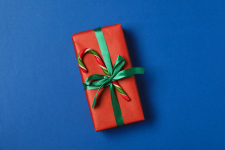 Decorated Christmas gift with candy cane on blue background, top viewの写真素材
