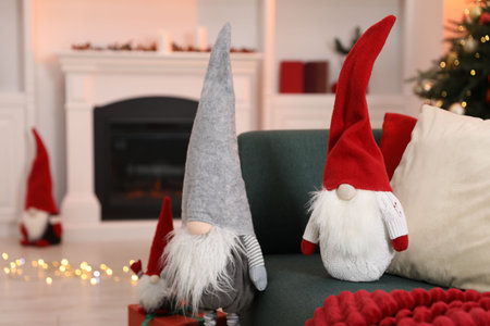 Funny Christmas gnomes on sofa in decorated room, closeupの写真素材
