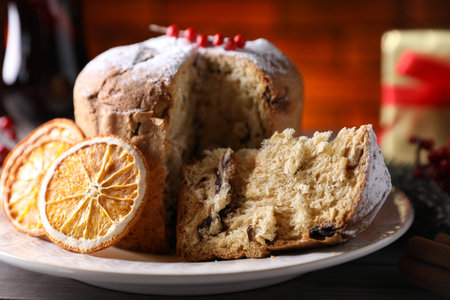 Christmas food. Delicious Panettone cake and festive decor on wooden table, closeupの写真素材