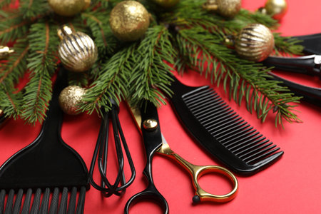 Different hairdresser's tools and Christmas decor on red background, closeupの写真素材