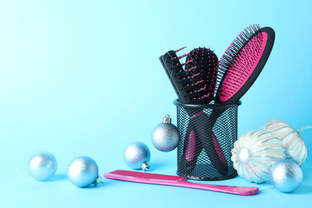 Different hairdresser's tools and Christmas decor on light blue background, closeup. Space for textの写真素材