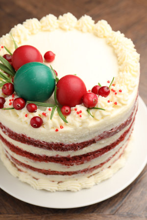 Delicious sponge cake with Christmas decor and red currants on wooden table, closeupの写真素材