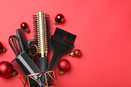 Different hairdresser's tools and Christmas decor on red background, flat lay. Space for textの写真素材