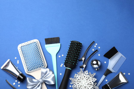 Different hairdresser's tools and Christmas decor on blue background, flat lay. Space for textの写真素材