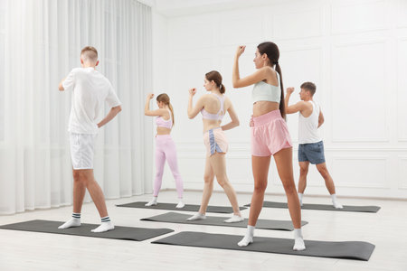 Group of people doing stretching exercise on fitness mats in gymの写真素材
