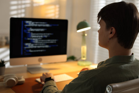 Programmer working on computer at table in officeの写真素材