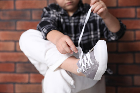 Little girl trying on stylish shoes indoors, closeupの写真素材