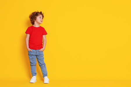 Portrait of cute little boy on yellow background, space for textの写真素材