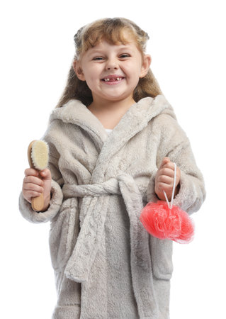 Cute girl in bathrobe with brush and loofah on white backgroundの写真素材